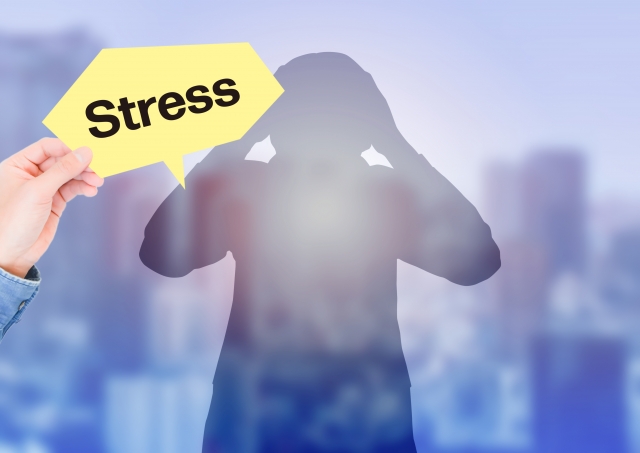 「Stress]」の文字と頭を抱える男性のシルエット
