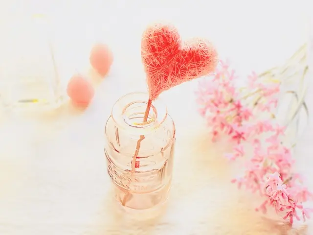ガラス瓶に入ったハートの飾りとピンク色の花